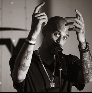 Marc Marcel mid-performance, hands raised to his temples